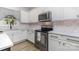 Close-up of the kitchen featuring white cabinets, quartz countertops, stainless steel appliances, and stylish backsplash at 9593 Indian Beech Nw Ave, Concord, NC 28027