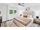Bedroom features a ceiling fan, plush bed, natural light and modern accents at 9826 Meringue Pl # 15, Charlotte, NC 28270