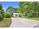 Charming home with mature trees, landscaping, a driveway and a welcoming yellow front door at 9826 Meringue Pl # 15, Charlotte, NC 28270