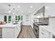 Bright kitchen with white cabinets, stainless steel appliances, quartz countertops, and modern pendant lighting at 9826 Meringue Pl # 15, Charlotte, NC 28270