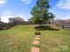 Expansive backyard featuring a fire pit, mature tree, and a spacious lawn perfect for outdoor entertaining at 10426 Kempsford Dr, Charlotte, NC 28262