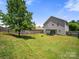 Expansive backyard with a large tree, wooden fence, and back patio of the house at 10426 Kempsford Dr, Charlotte, NC 28262
