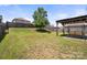 Large backyard features a spacious lawn, mature tree, wood fence, and shaded patio area at 10426 Kempsford Dr, Charlotte, NC 28262