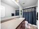 This bathroom features a single sink vanity, dark cabinetry, framed mirror, and shower with dark shower curtain at 10426 Kempsford Dr, Charlotte, NC 28262