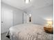Cozy bedroom showcasing neutral paint, soft lighting, and convenient access to the adjacent bathroom and closet at 10426 Kempsford Dr, Charlotte, NC 28262