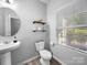 This powder room features a pedestal sink, modern fixtures, a window, and stylish décor at 10426 Kempsford Dr, Charlotte, NC 28262