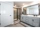 Modern bathroom featuring a double vanity, walk-in shower with glass door, and neutral tiles at 11951 Old Statesville Rd, Huntersville, NC 28078