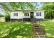 A quaint single-story house with a black porch and a grassy front yard at 1211 11Th Nw St, Hickory, NC 28601