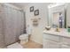 Bright bathroom featuring a shower/tub combo, neutral-toned walls, and vanity with decorative accents at 12822 Plumleaf Dr, Charlotte, NC 28213