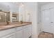 Bathroom with double sink vanity with granite countertop, white cabinets, and travertine shower and flooring at 12822 Plumleaf Dr, Charlotte, NC 28213