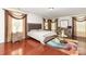 Spacious bedroom with hardwood floors, decorative drapes, a decorative rug, and modern furniture at 12822 Plumleaf Dr, Charlotte, NC 28213