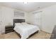Well-lit bedroom featuring a carpeted floor, decorative curtains and artwork over the headboard at 12822 Plumleaf Dr, Charlotte, NC 28213