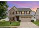 Two-story home featuring a stone facade, well-manicured lawn, and a two-car garage under a dramatic sky at 12822 Plumleaf Dr, Charlotte, NC 28213