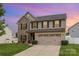 Charming two-story home featuring stone accents, a two-car garage, and a well-maintained front lawn at 12822 Plumleaf Dr, Charlotte, NC 28213