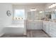 Bright bathroom with a soaking tub, double vanity, and a large sunlit window at 13338 Blanton Dr, Huntersville, NC 28078