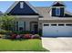 Charming home featuring a brick facade, well-manicured lawn, and a welcoming front porch at 13338 Blanton Dr, Huntersville, NC 28078