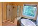 Bathroom featuring a tub, seamless glass shower, and window bringing in lots of natural light at 15494 Donnington Dr, Charlotte, NC 28277