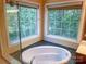 Sunlit bathroom showcasing a tub, expansive window views, and tile accents for a luxurious feel at 15494 Donnington Dr, Charlotte, NC 28277