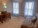 Comfortable bedroom with wood desk, daybed, and natural light, offering a cozy space at 15494 Donnington Dr, Charlotte, NC 28277