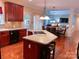 Open kitchen featuring a central island with seating, seamlessly connected to a dining area and living space at 15494 Donnington Dr, Charlotte, NC 28277