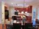 Spacious kitchen and dining area featuring wood cabinets, an island, and pendant lighting at 15494 Donnington Dr, Charlotte, NC 28277