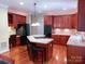 Beautiful kitchen area featuring warm wood cabinets, island seating, and modern appliances at 15494 Donnington Dr, Charlotte, NC 28277