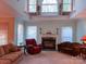 Spacious living room featuring high ceilings, a fireplace, and large windows for plenty of natural light at 15494 Donnington Dr, Charlotte, NC 28277