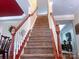 Carpeted staircase with white spindles and stained wood handrail leads to the upper level at 15494 Donnington Dr, Charlotte, NC 28277