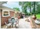 Relaxing outdoor living on brick patio with dining table and chairs overlooking well-manicured yard at 1571 10Th Street Nw Pl, Hickory, NC 28601