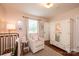 Charming Bedroom with a crib, soft lighting, a cozy armchair, and neutral decor at 1571 10Th Street Nw Pl, Hickory, NC 28601