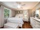 Cozy bedroom with wood floors, neutral walls, white furniture, and natural light from two windows at 1571 10Th Street Nw Pl, Hickory, NC 28601