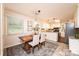 Sunlit dining area with wooden table, neutral chairs, and convenient access to the kitchen at 1571 10Th Street Nw Pl, Hickory, NC 28601