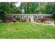 Charming brick ranch home with lush lawn, colorful landscaping, and covered parking at 1571 10Th Street Nw Pl, Hickory, NC 28601