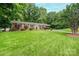 Inviting single-story brick home with a green lawn, mature trees, and an attached carport at 1571 10Th Street Nw Pl, Hickory, NC 28601
