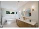 Bright bathroom featuring a modern vanity with double sinks, soaking tub, and decorative gold fixtures at 1625 Club Rd, Charlotte, NC 28205