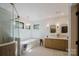 Bright bathroom featuring a modern vanity with double sinks, soaking tub, and decorative gold fixtures at 1625 Club Rd, Charlotte, NC 28205