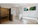 Elegant bathroom featuring glass shower, soaking tub with a chandelier, and a closet at 1625 Club Rd, Charlotte, NC 28205