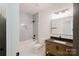 Bathroom featuring a bathtub, mosaic tile, wood vanity and modern mirror at 1625 Club Rd, Charlotte, NC 28205