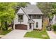 Charming two-story painted brick home with a well-manicured lawn and a stylish brown garage door at 1625 Club Rd, Charlotte, NC 28205