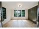 Bright living room featuring hardwood floors, a stylish light fixture, and large windows offering natural light at 1625 Club Rd, Charlotte, NC 28205