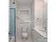 Bright bathroom with blue tiled shower, white wainscoting, and marble countertop at 1720 Chatham Ave, Charlotte, NC 28205