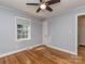 Cozy bedroom featuring hardwood floors, ceiling fan and a bright window for natural lighting at 1720 Chatham Ave, Charlotte, NC 28205