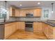 Well-lit kitchen featuring light wood cabinets, black countertops, and stainless steel appliances at 1720 Chatham Ave, Charlotte, NC 28205