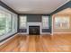 Spacious living room with hardwood floors, a fireplace, and natural light at 1720 Chatham Ave, Charlotte, NC 28205