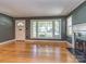 Bright living room featuring hardwood floors, large windows, and a cozy fireplace at 1720 Chatham Ave, Charlotte, NC 28205