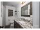 Bathroom vanity with granite countertop, decorative mirror, and bathtub/shower combo at 1761 Arden Dr, Lincolnton, NC 28092