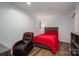 Cozy bedroom featuring a red bedspread, hardwood floors, and a gaming chair at 1761 Arden Dr, Lincolnton, NC 28092