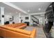 Open-concept living room featuring a leather sectional sofa, modern staircase, and a brick fireplace at 1761 Arden Dr, Lincolnton, NC 28092