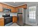 Well-lit kitchen with stainless steel appliances, wooden cabinets, and gray backsplash at 1890 Sandal Brook Rd, Fort Mill, SC 29707