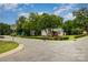 Street corner with tree coverage and well-manicured lawns with a home at 2308 Vanderbilt Rd, Charlotte, NC 28206